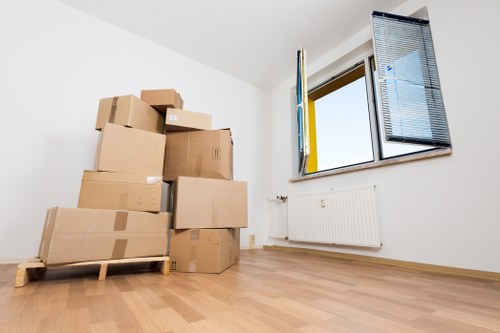 Professional movers carrying furniture from a flat in West London
